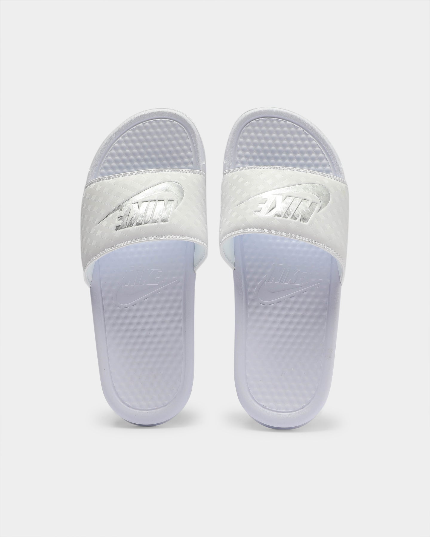 white and silver nike slides